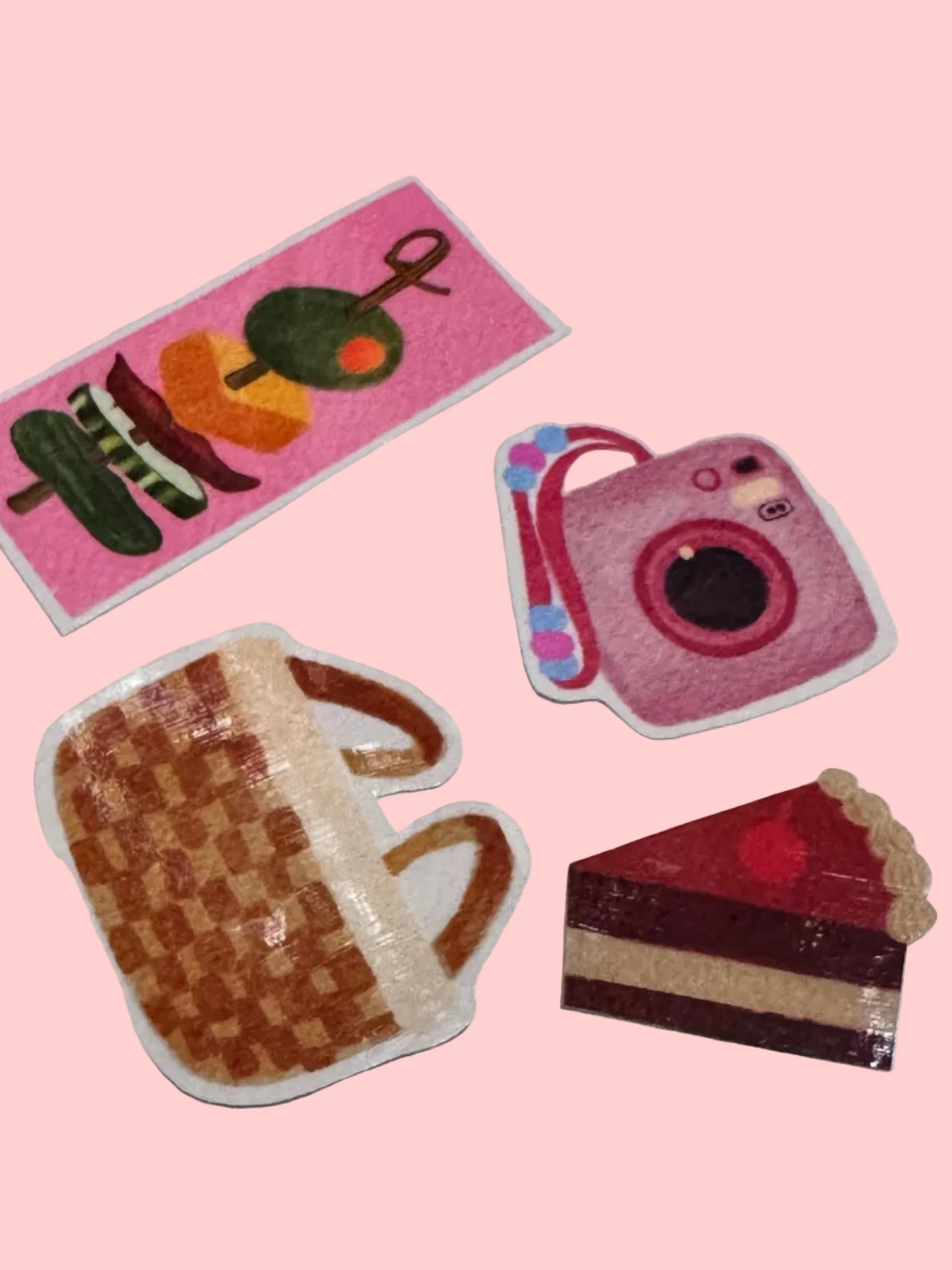Set of colorful vinyl stickers on a white surface, including a camera, waffle, and cake slice.