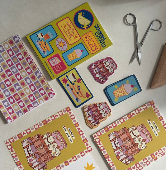 Colorful journalling supplies and stickers on a white surface with scissors.