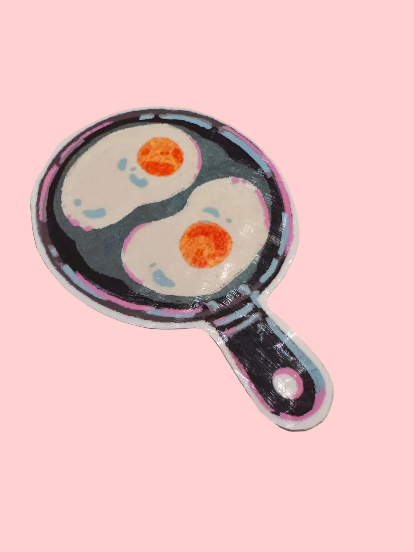 Sticker of two eggs in a frying pan on a gray background